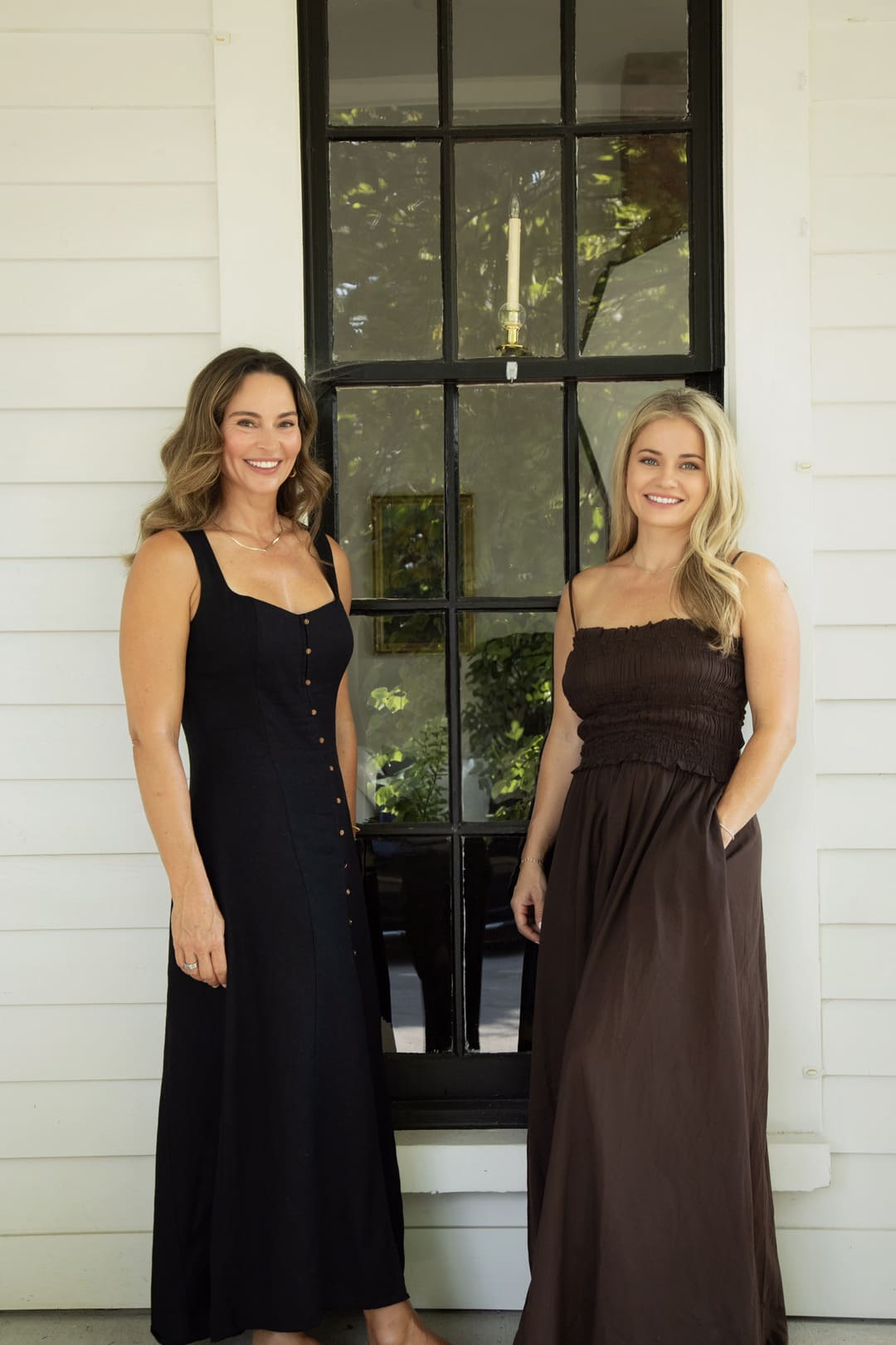 Two women standing in front of a classic window at SKINHAUS
